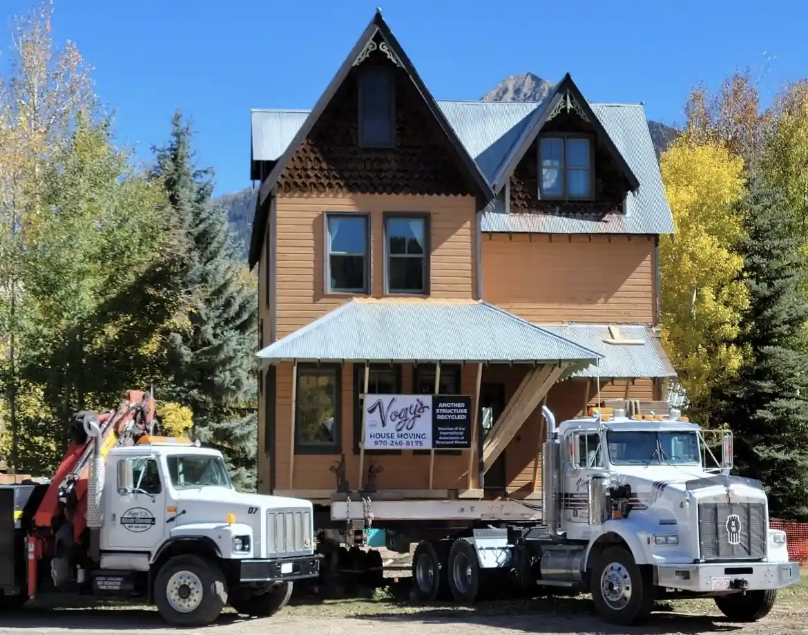 Vogy's house moving trucks with a house on top of the trailer